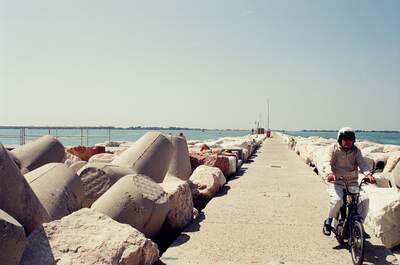 A boy cycling along the Lido breakwater — Venice, Italy (6-10 June 2000)