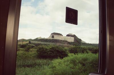 A hilltop ruin glimpsed from a moving train window — On the sleeper to Glasgow, Scotland (20-25 July 2000)