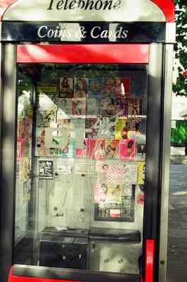 Contact cards plastered inside a red telephone box — London, England (20-25 July 2000)