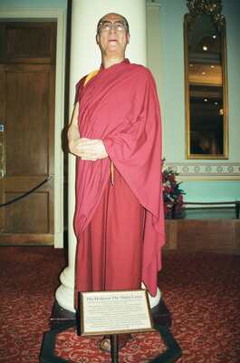A waxwork of the Dalai Lama in red robes — London, England (20-25 July 2000)