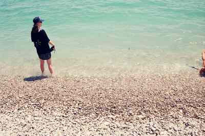 A woman paddling on the pebble beach of the Cote d'Azur — Nice, France (13-20 July 2000)
