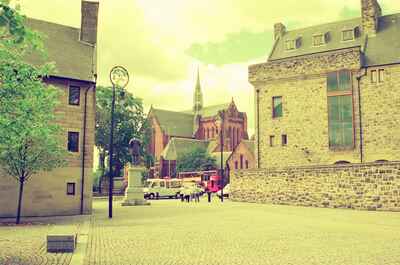 The cobbled cathedral precinct with a statue and the spire beyond — Glasgow, Scotland (late July 2000)