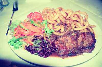 A plate of peppered steak with curly fries and salad — Glasgow, Scotland (late July 2000)