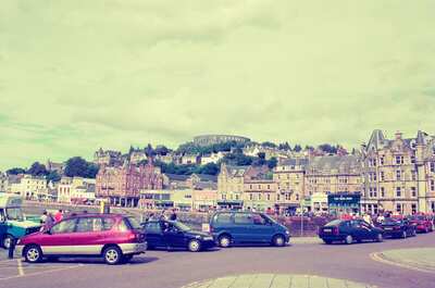 The Oban seafront with McCaig's Tower on the hill above — Oban, Scotland (late July 2000)