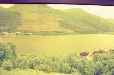 A Highland loch and hills seen through the train window — Scottish Highlands, Scotland (late July 2000)